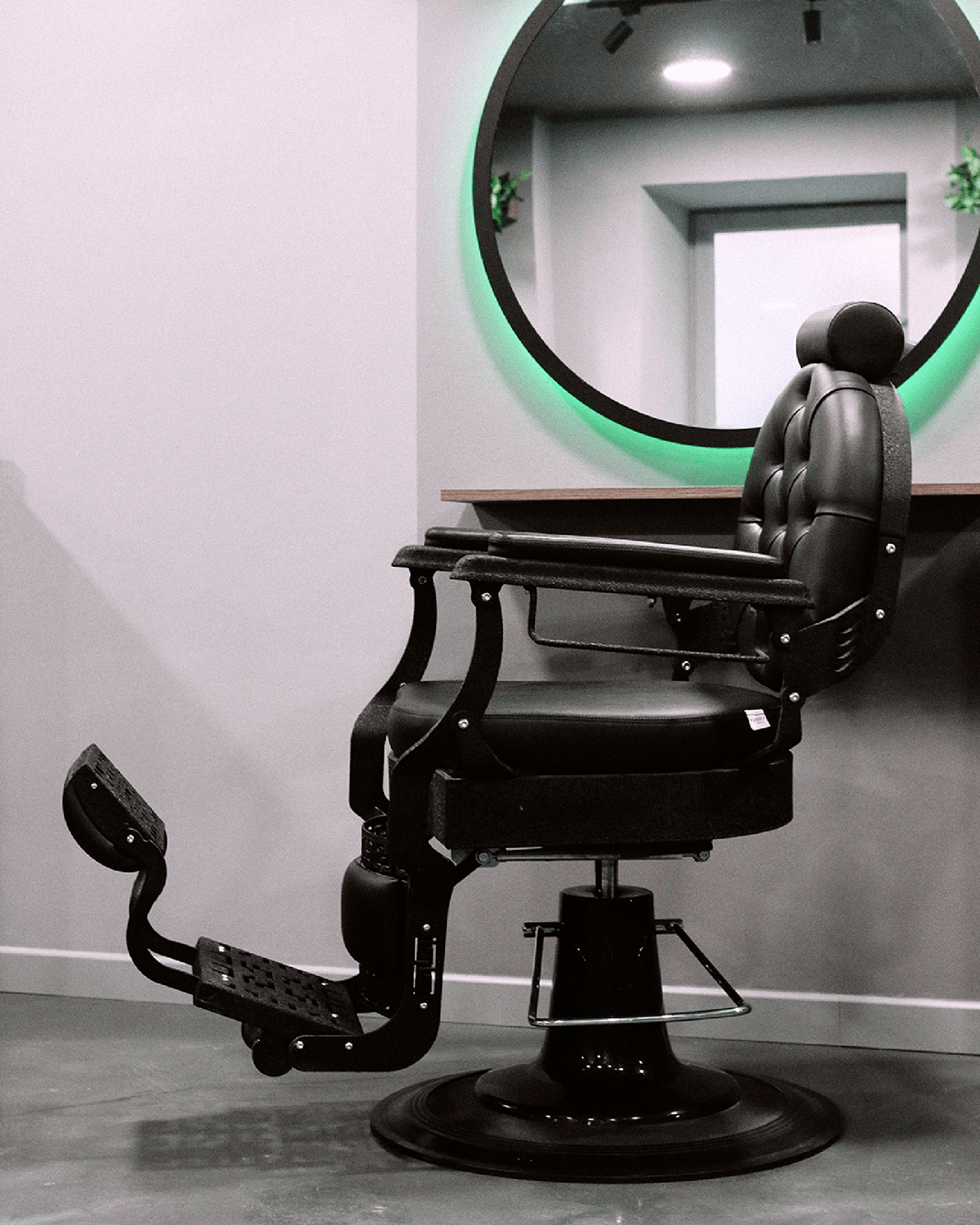 Scaunul de barber și oglinda circulară din salonul Men’s Crown